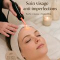 Femme recevant un facial anti-acné dans un environnement apaisant.