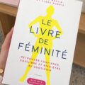Une sélection de livres inspirants sur la féminité disposés sur une table en bois.